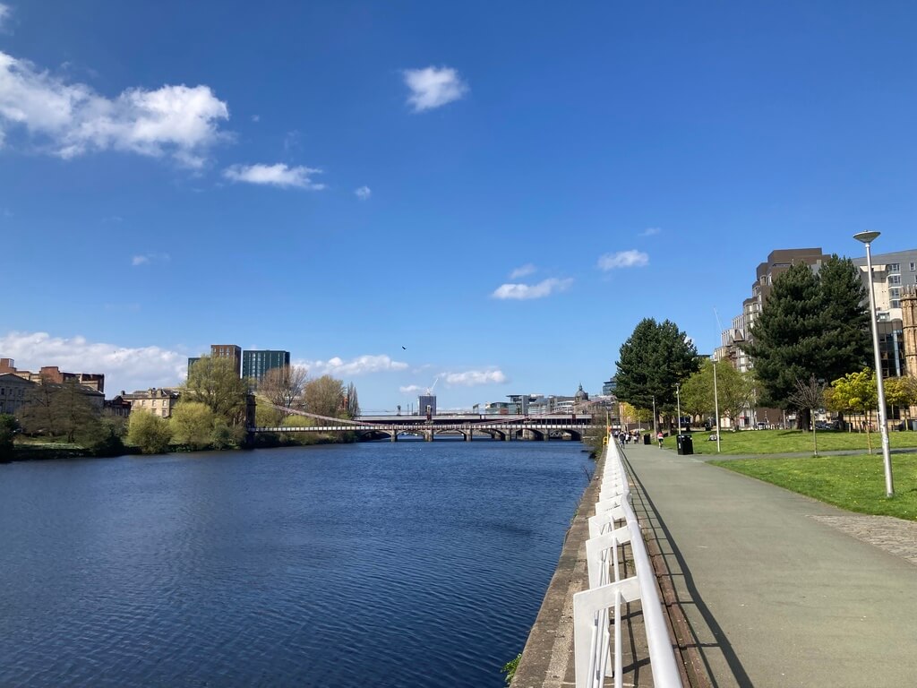 A footpath running alongside the River Clyde, with a bridge in the background